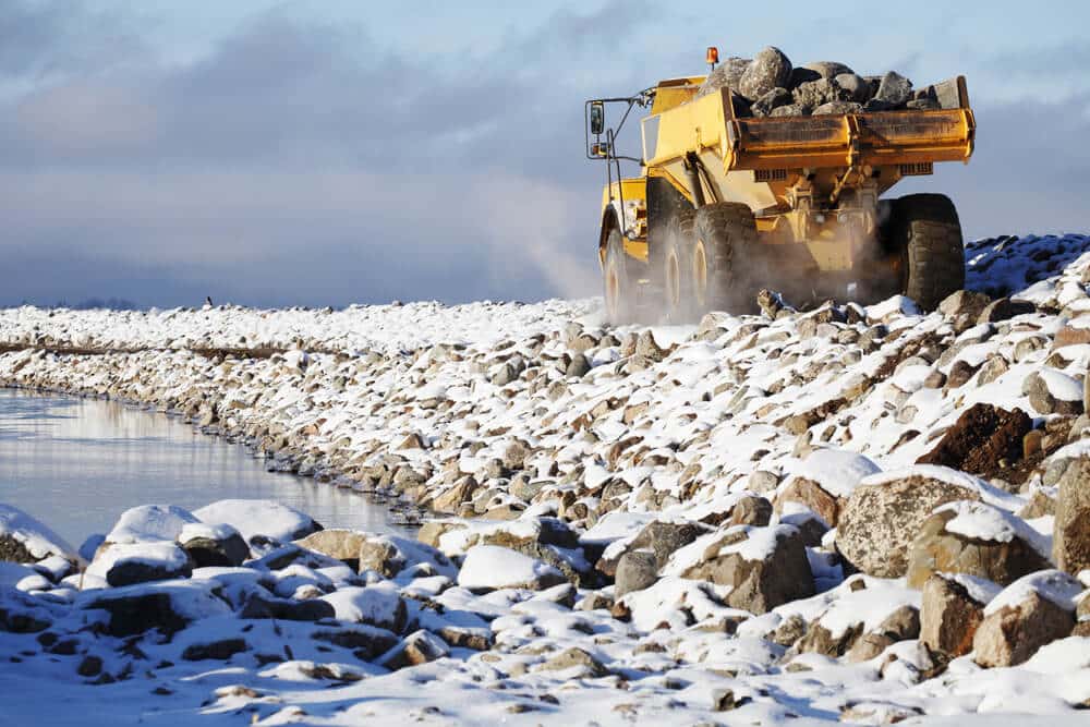 heavy,truck,delivering,rocks,and,driving,on,narrow,pier