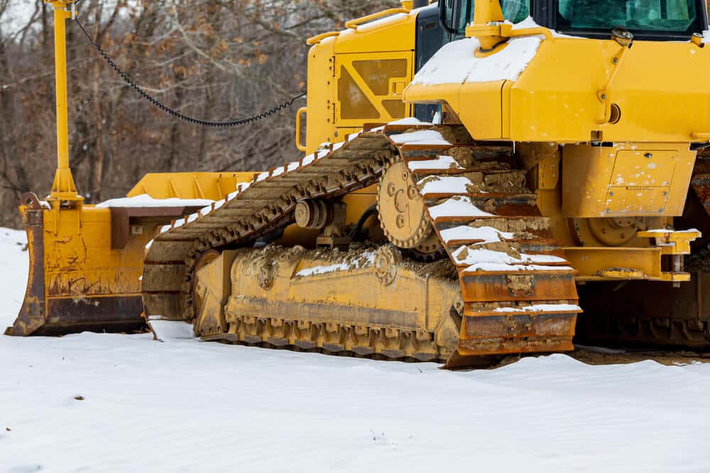 bulldozer at construction site after winter snow storm